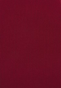 Tissu côtelé bourgogne avec une texture verticale, présentant des lignes régulières et une finition lisse. Matériau léger adapté à l'habillement.