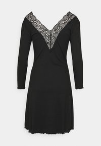 Vestido preto de mangas longas com um decote em V profundo acentuado por renda preta intrincada, silhueta fluída e bainha ondulada.