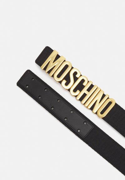Črn usnjen pas z zlatim napisom "MOSCHINO" na sponki, z gladko teksturo in več prilagoditvenimi luknjami.