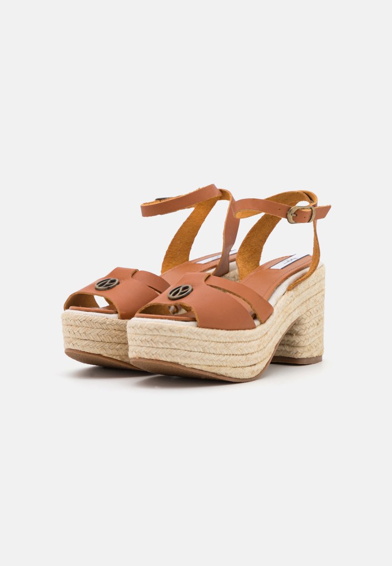 Sandalias de cuero marrón con correas anchas y punta redonda. Presentan un tacón de cuña estilo espadrille con envoltura de yute texturizado.