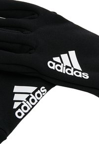 Zwarte sportieve handschoenen van stof, met het witte Adidas-logo en het ontwerp van drie strepen op elke pols. Gladde textuur, aansluitende vorm.