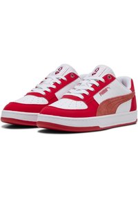 Baskets rouges et blanches avec un logo PUMA en daim, dessus en cuir lisse, bout perforé et accents texturés. Lacets plats et semelle en caoutchouc.