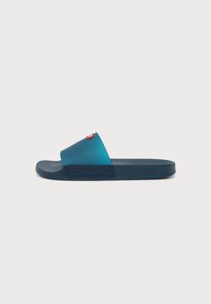 Blaue Badesandale mit breitem Riemen, leicht transparentem Obermaterial und kleinem rot-weißen Labeldetail, im Profil auf weißem Hintergrund dargestellt.