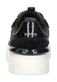 Zwarte sneaker met een getextureerde bovenkant, glanzende accenten en een witte chunky zool. Heeft een treklus en logo-details bij de hak.