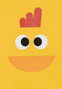 Yellow fabric featuring a cartoon chicken face with large white eyes, black pupils, an orange beak, and a red comb on top.