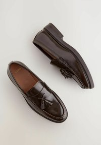 Braune Lederloafers mit glatter Oberfläche, dekorativem Quasten, genähten Details und flachem Absatz.