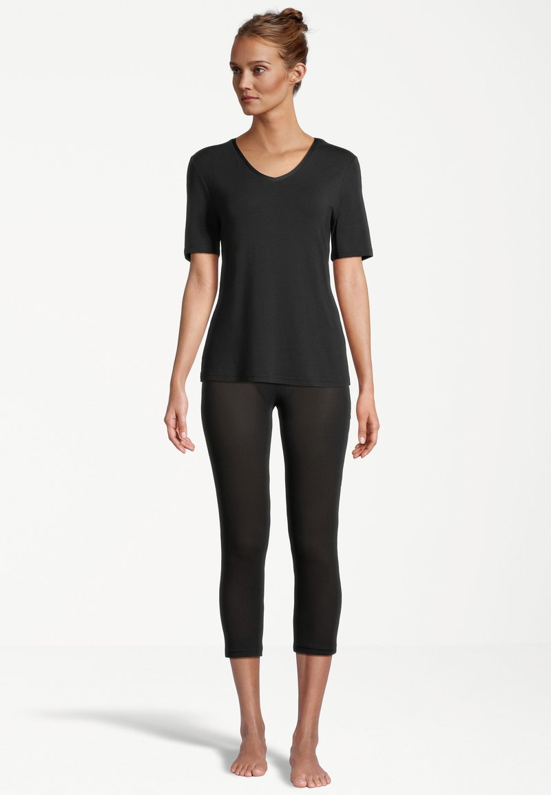 Schwarzes V-Ausschnitt-T-Shirt mit kurzen Ärmeln, kombiniert mit schwarzen, knöchellangen Leggings. Hergestellt aus einem glatten, dehnbaren Stoff, der eine figurbetonte Silhouette bietet.