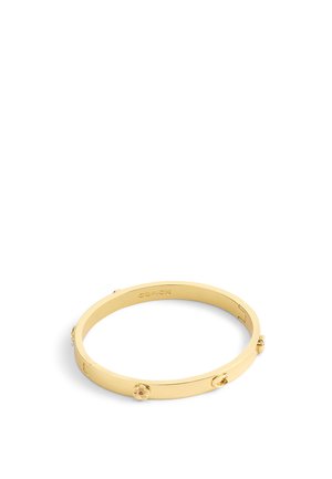 Bracciale a bangle in metallo tono oro con accenti floreali e una finitura liscia e lucida. Incisione distintiva del brand all'interno.