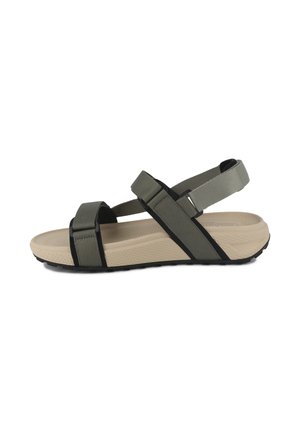 Sandales en tissu vert avec accents noirs, dotées de lanières croisées et d'une semelle beige rembourrée. Semelle inférieure texturée pour une meilleure adhérence.