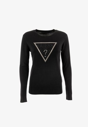 Suéter negro con un diseño triangular que presenta un logo "GUESS" texturizado, adornado con acentos plateados y tachuelas en la parte frontal.