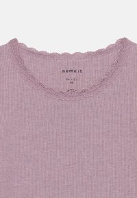 Top a coste lilla con scollatura ondulata e bordo in pizzo. L'etichetta riporta "name it" con la taglia 92 (1½ - 2 anni) stampata all'interno.