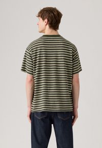 Camisa de manga curta com riscas horizontais em verde oliva e creme, feita de tecido suave, com um corte descontraído e decote redondo.