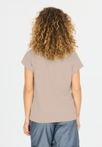 Korte mouwen, taupekleurig shirt met een ontspannen pasvorm. Gladde textuur, eenvoudig ontwerp en ronde halslijn. Gecombineerd met denim shorts.