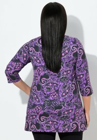 Lila Paisley-Drucktunika mit dreiviertel Ärmeln, schwarzem Hintergrund und floralen Akzenten, aus einem glatten Stoff gefertigt.