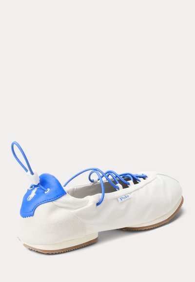 Zapato casual de la marca Polo en blanco y azul con cordones azules, lengüeta de cuero en el talón, lazo para tirar y suela de goma, vista desde la parte trasera.