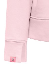 Lichtroze sweatshirt van een textuurstof. Heeft een gespleten manchet en een klein, geborduurd label in het roze met een hondenlogo.