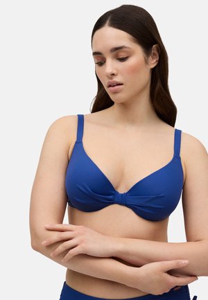 Top de bikini azul con una textura suave, copas moldeadas y un detalle de nudo en el centro. Las tirantes ajustables complementan el diseño.