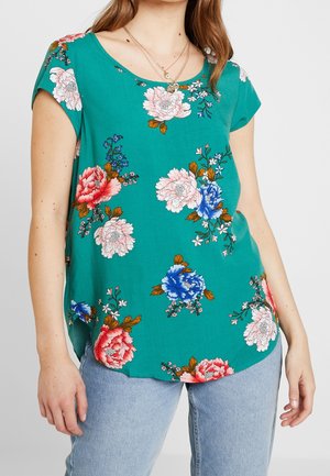 Korte ærmer teal top med blomsterprint i pink, blå og hvid. Blødt stof med en afslappet pasform og buet kant.