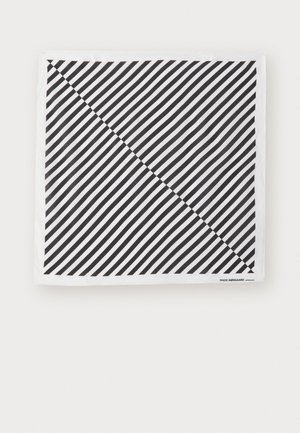 Bufanda en blanco y negro con rayas diagonales. El material es suave y tiene una textura lisa. Etiqueta de la marca en la esquina inferior derecha.