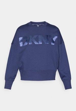 Navy cropped sweatshirt featuring a large, reflective DKNY logo. Made from soft fabric with relaxed fit and ribbed cuffs and hem.