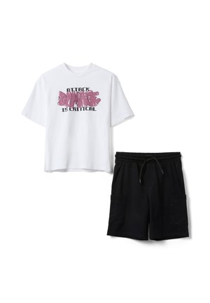 Witte T-shirt met korte mouwen met de tekst "Attack Damage is Critical" gecombineerd met zwarte cargoshorts met koord op een witte achtergrond.