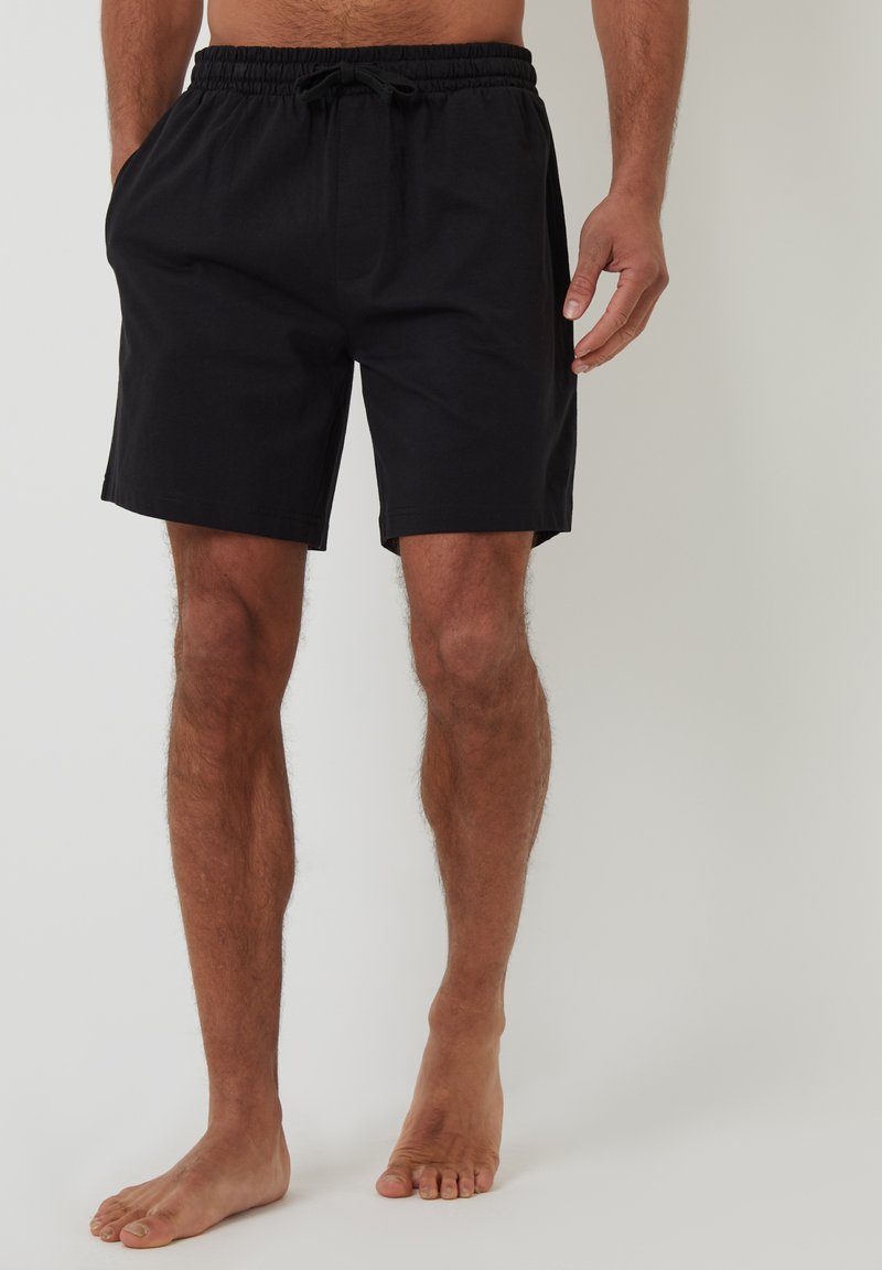 Pantaloni corti neri realizzati in tessuto leggero con vita elastica e cordoncino. Presentano tasche laterali e una vestibilità rilassata con taglio dritto.