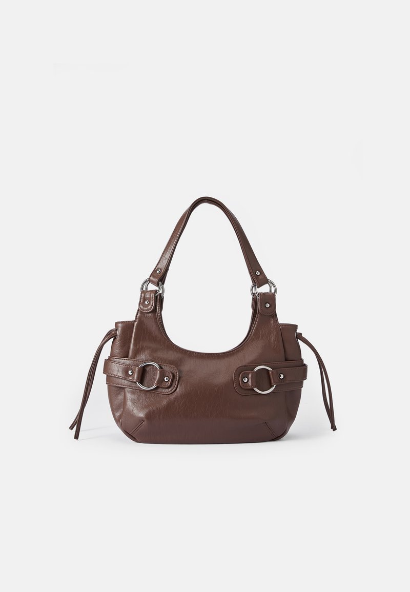 Bolsa de mão de couro castanho com um formato curvado, acabamentos em metal prateado e alças laterais atadas com nós. Textura lisa com detalhes mínimos.