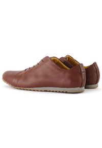 Brązowe skórzane buty o eleganckim wzornictwie, okrągłym nosku, pięciu oczkach oraz teksturowanej gumowej podeszwie. Wnętrze charakteryzuje się kontrastowym żółtym wykończeniem.