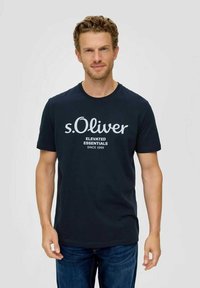 Navy T-Shirt aus Baumwolle mit weißem "s.Oliver" Logo und dem Text "ELEVATED ESSENTIALS" darunter. Kurzarm, Rundhalsausschnitt, lässige Passform.