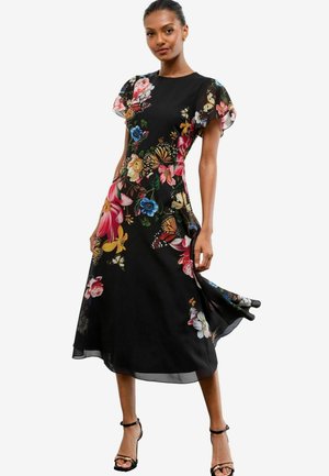 Abito midi nero floreale con maniche corte a volants, caratterizzato da un mix di fiori colorati e farfalle. Tessuto leggero e fluido con un orlo.