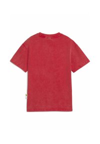 Camiseta roja de manga corta con textura desgastada, cuello redondo y dobladillos cosidos. Se puede ver una etiqueta con el logo en la parte inferior izquierda.