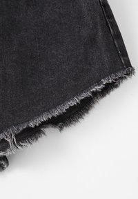 Black denim shorts with frayed hemline, featuring a slightly faded texture. Cut-off style with raw edges, showcasing contrast stitching details.