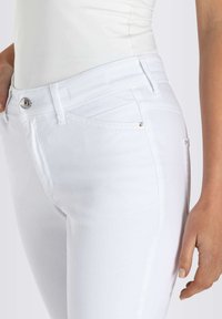 Witte spijkerbroek van denim met een aansluitend ontwerp, met achterzakken, zilveren hardware accenten en een gladde textuur.