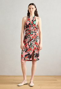 Šaty s květinovým potiskem v černé, růžové a zelené barvě; design s halter krkem, přiléhavý pas, sukně ke kolenům se bočním rozparkem. Hladká textura tkaniny.