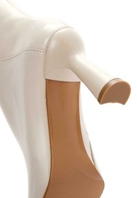 Witte leren hoge hak schoenen met een spitse neus en een slank ontwerp. Heeft een gladde buitenkant en een contrasterende tan buitenzool.