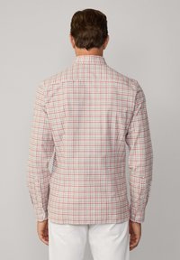 Herren-Hemd mit langen Ärmeln in rot-weißem Karomuster, aus weichem Stoff, mit Punktkragen und Knopfmanschetten, von hinten gezeigt.