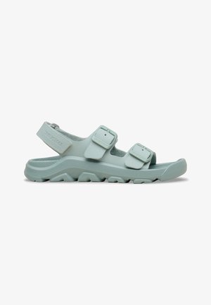Sandalia Birkenstock gris claro con tres tiras ajustables y una suela resistente y texturizada para uso al aire libre.