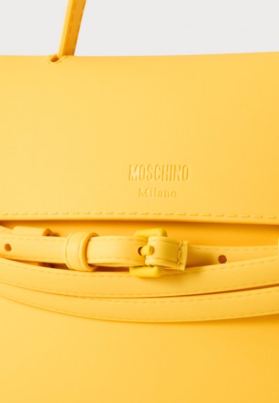 Sac à main en cuir jaune Moschino Milano avec bandoulière réglable et détail boucle.