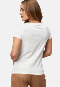 T-shirt blanc à manches courtes, fabriqué en tissu doux, avec un col rond et une coupe décontractée, vu de l'arrière avec une texture lisse.