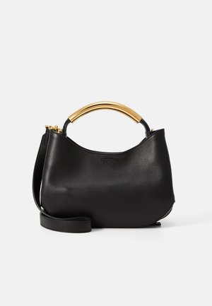 Sac à main en cuir noir avec une forme courbée, poignée en métal doré et bandoulière amovible. Texture lisse, design minimaliste et sans motifs.