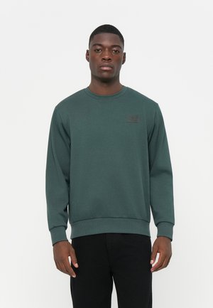Dunkelgrüner Sweatshirt mit Rundhalsausschnitt und langen Ärmeln. Verfügt über ein rechteckiges Stoffetikett auf der Brust. Glatte Textur, lockere Passform.