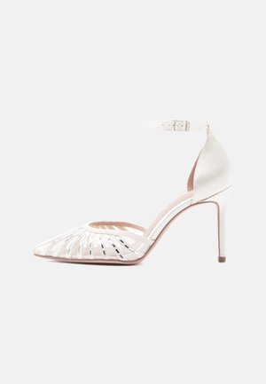 Pointed-toe high-heeled shoe in soft white satin with cut-out design, delicate ankle strap, and slender stiletto heel.