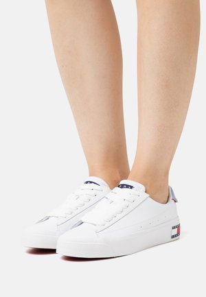 Zapatillas de cuero blanco con suelas de goma texturizadas, diseño de cordones y un sutil logo en el talón. Cuenta con un cuello acolchado para mayor comodidad.
