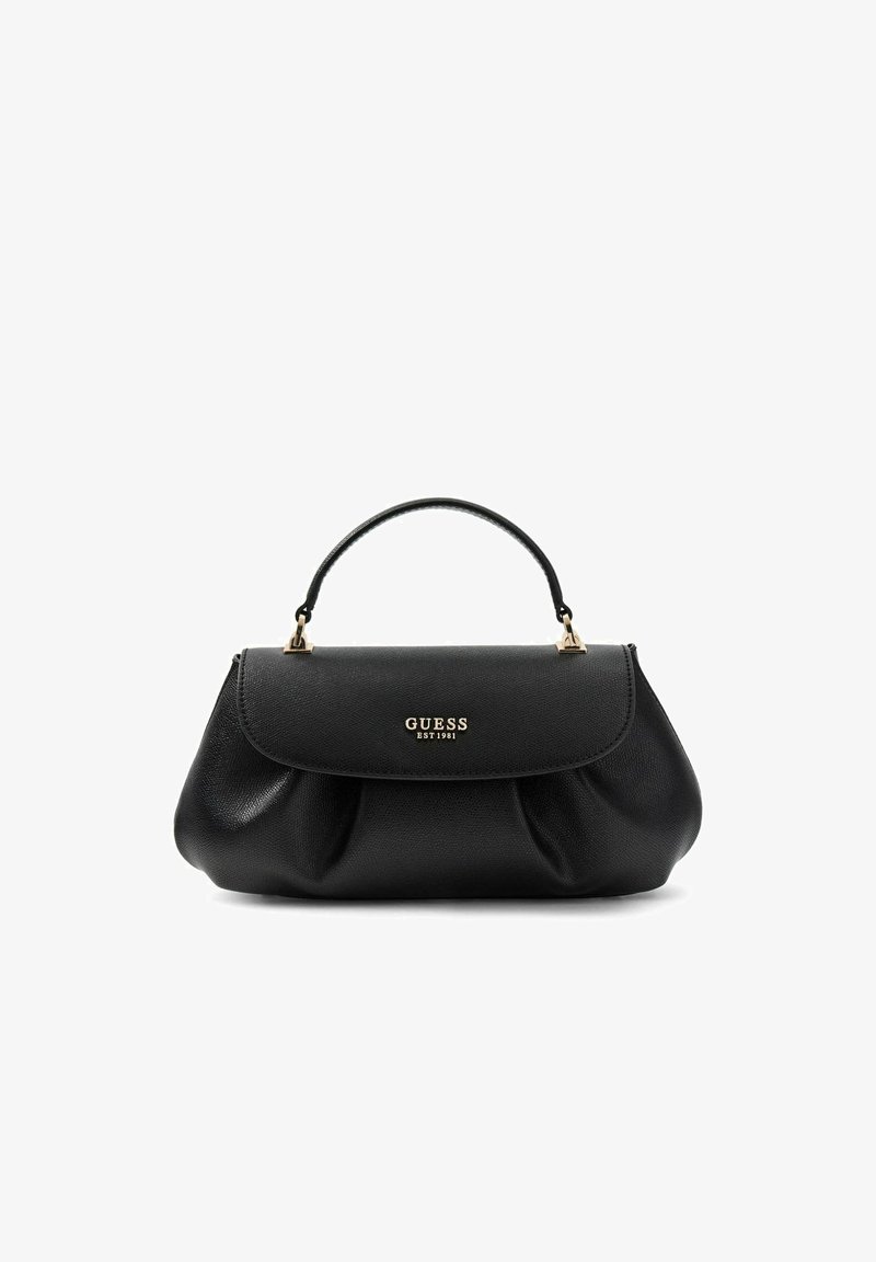 Μαύρη δερμάτινη τσάντα Guess με χρυσλό λογότυπο και μία χειρολαβή πάνω, σε λευκό φόντο.