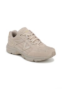 Sneaker beige in suede con chiusura con lacci, lati testurizzati e suola leggera. Presenta sottili accenti metallici e un colletto imbottito per il comfort.