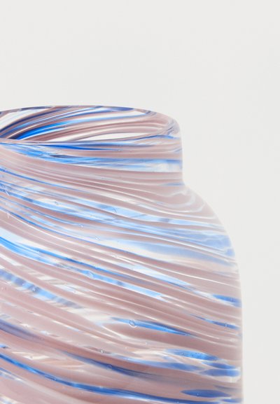 Κοντινό πλάνο ενός λείου, καμπυλωτού γυάλινου βάζου με στροβιλιζόμενες μπλε και ροζ ρίγες σε ανοιχτό φόντο.