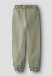 Jasnozielone dresy wykonane z miękkiego materiału, z elastycznym pasem i prążkowanymi ściągaczami przy kostkach. Prosty, minimalistyczny design.