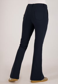 Marineblauwe wijde broek gemaakt van een rekbare stof, met een gladde textuur, achterzakken en een tailleband met een middenhoogte.