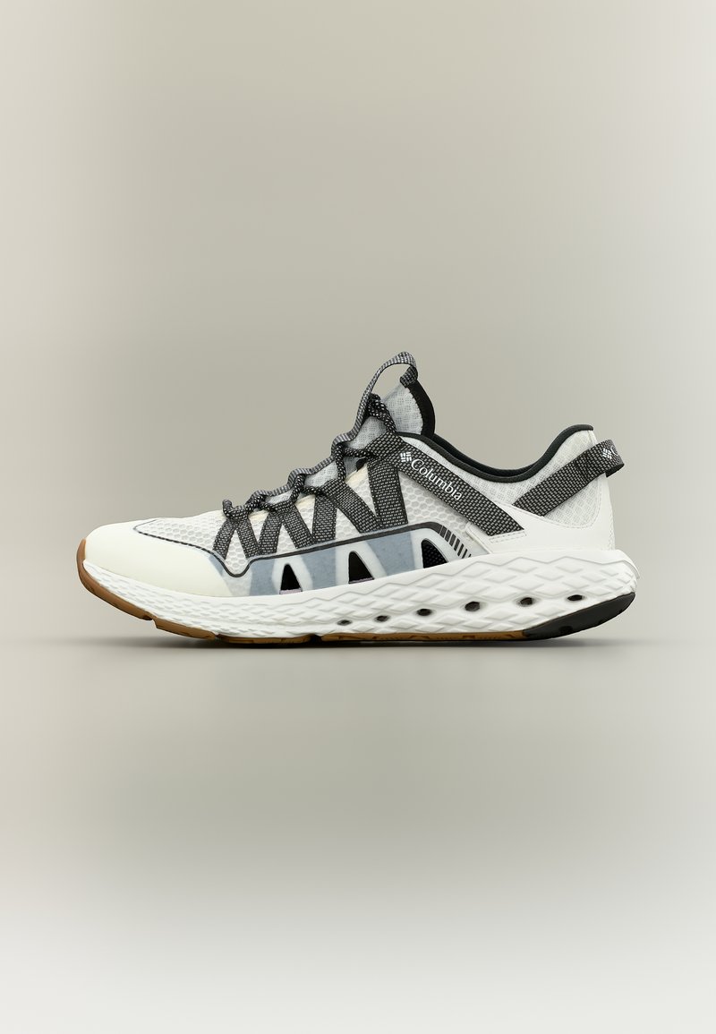 Άσπρο και γκρι αθλητικό παπούτσι με μαύρα κορδόνια από δίχτυ, παχιά μαξιλαρωμένη σόλα και λογότυπο Columbia στο πλάι, τοποθετημένο σε ουδέτερο φόντο.