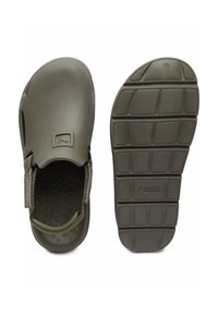 Olíva zöld slip-on cipők texturált felsőrésszel, párnázott pánttal és logós mintás gumitalppal. Könnyű és ergonómikus kialakítás.